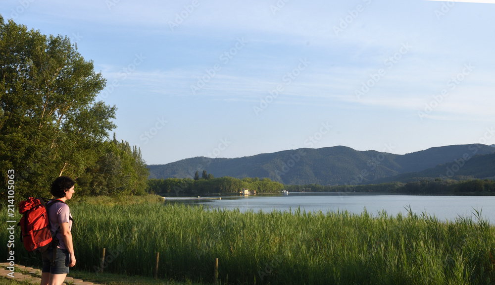 female hiker in front of a lake when evening