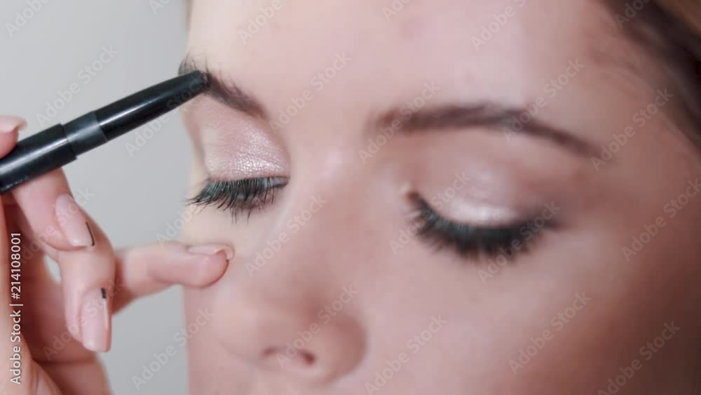 Visagist paints eyes with eyeshadow a young girl Visagist paints eyes with eyeshadow a young girl