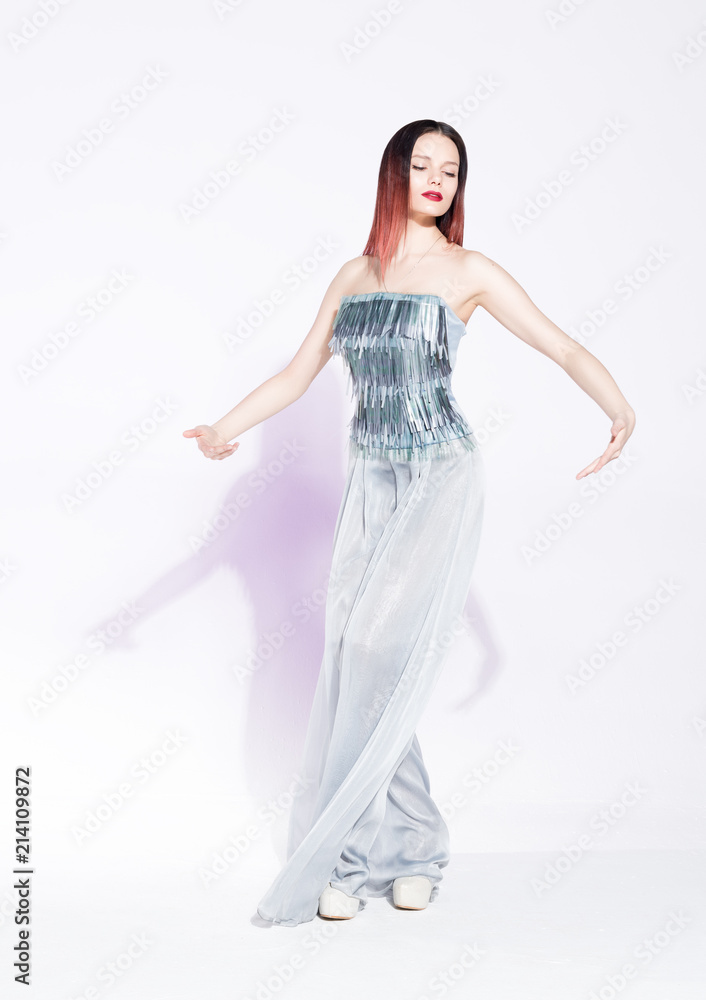 Fashion portrait of a dancing lady. Beautiful young woman in fashionable stylish dress on a white background Fashion portrait of a dancing lady. Beautiful young woman in fashionable stylish dress on a white background