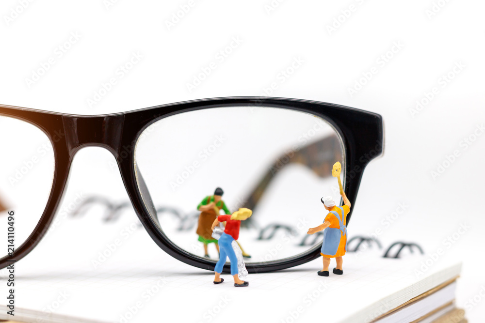 Miniature people worker cleaning eyes glasses on book. Clear Vision concept. Miniature people worker cleaning eyes glasses on book. Clear Vision concept.