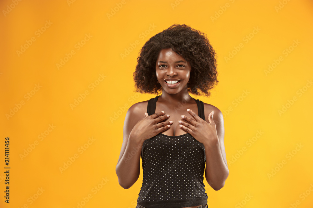 The happy business woman standing and smiling against gold background. The happy business woman standing and smiling against gold background.