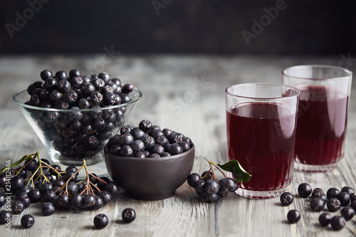 Fresh aronia berries and aronia berry juice in glasses