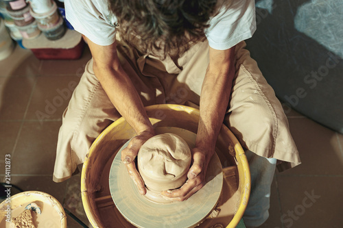 Creating a jar or vase of white clay close-up. Master crock. photo