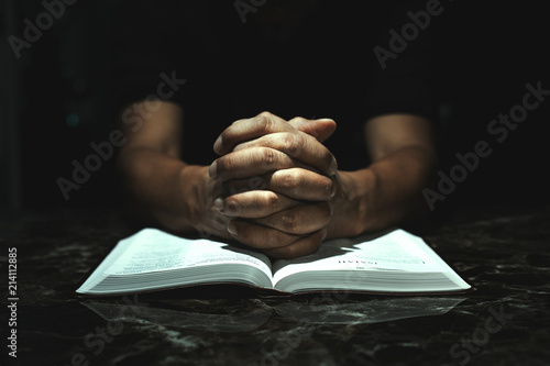 Men praying to God on his desk