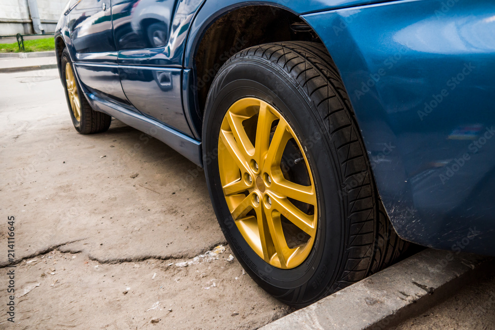 A car with beautiful wheels. In the parking lot near the business center the view is from below. A car with beautiful wheels. In the parking lot near the business center the view is from below.