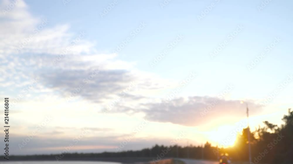 Biker on motorcycle riding on the road at sunset background Biker on motorcycle riding on the road at sunset background