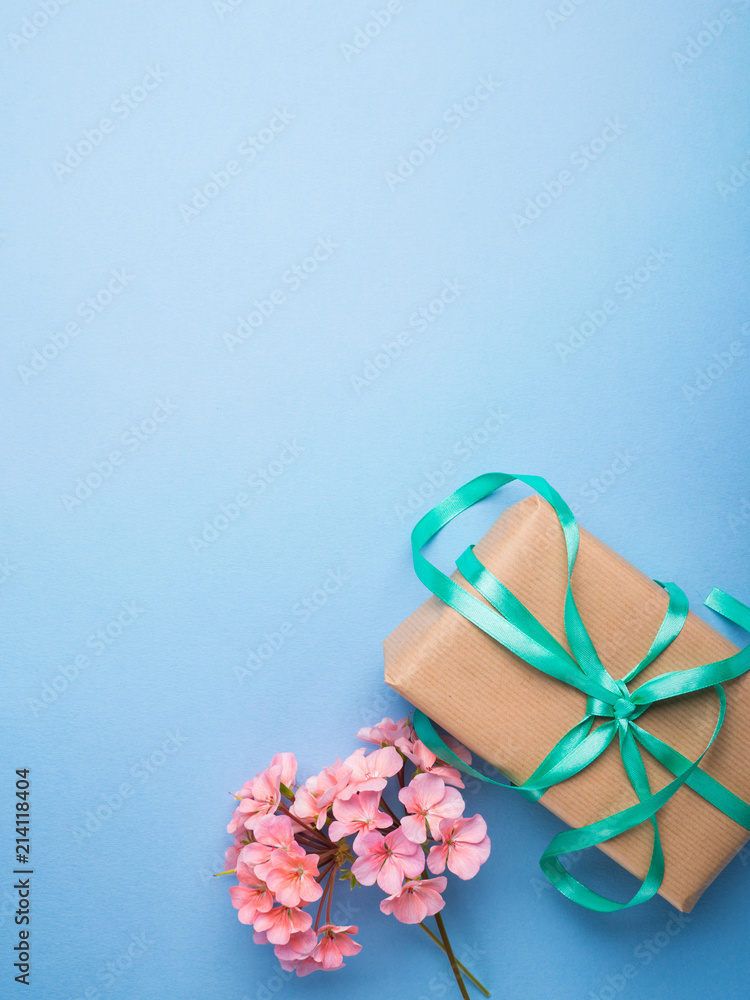 Wrapped gift and pink flowers flat lay. Gift for mother woman day, wedding, valentine concept