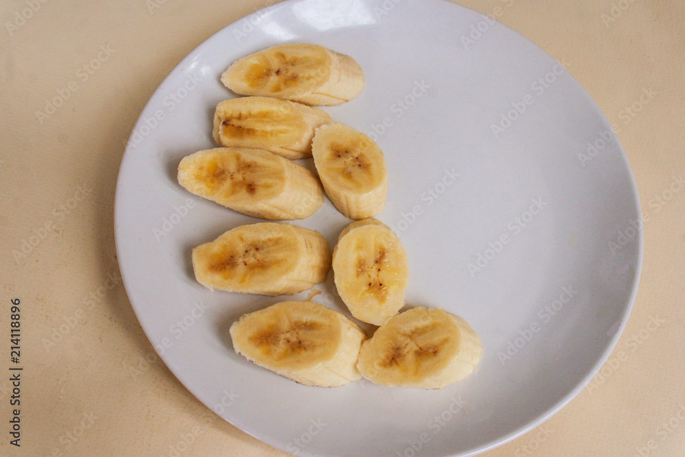 Pieces of banana on a plate. Candid.