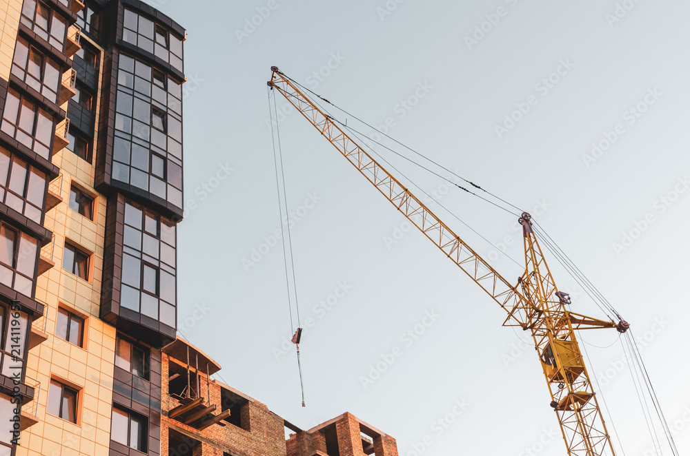 Crane at a construction site in sunset light. Bottom view. Crane at a construction site in sunset light. Bottom view.