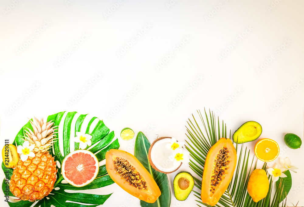 fresh exotic fruits with green tropical leves flat lay top view border, summer diet background, retro toned