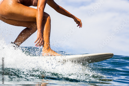 Closeup of beautiful young Sporty girl in a bikini swimsuit ride big wave with lot of splashes. Fit surfer woman surfing in Mauritius in the Indian Ocean on the transparent waves. Outdoor Active Life.