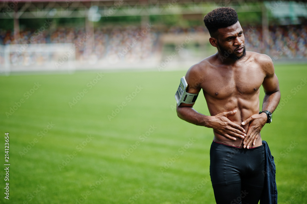 African american male athlete sexy sport bare torso man with running sports  arm case for mobile phone, posed at green grass of football stadium. Stock  Photo | Adobe Stock