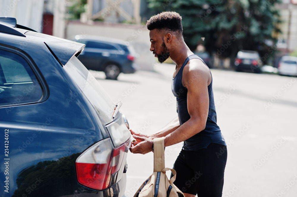 African american male athlete sport man with backpack against his black suv car before training. African american male athlete sport man with backpack against his black suv car before training.