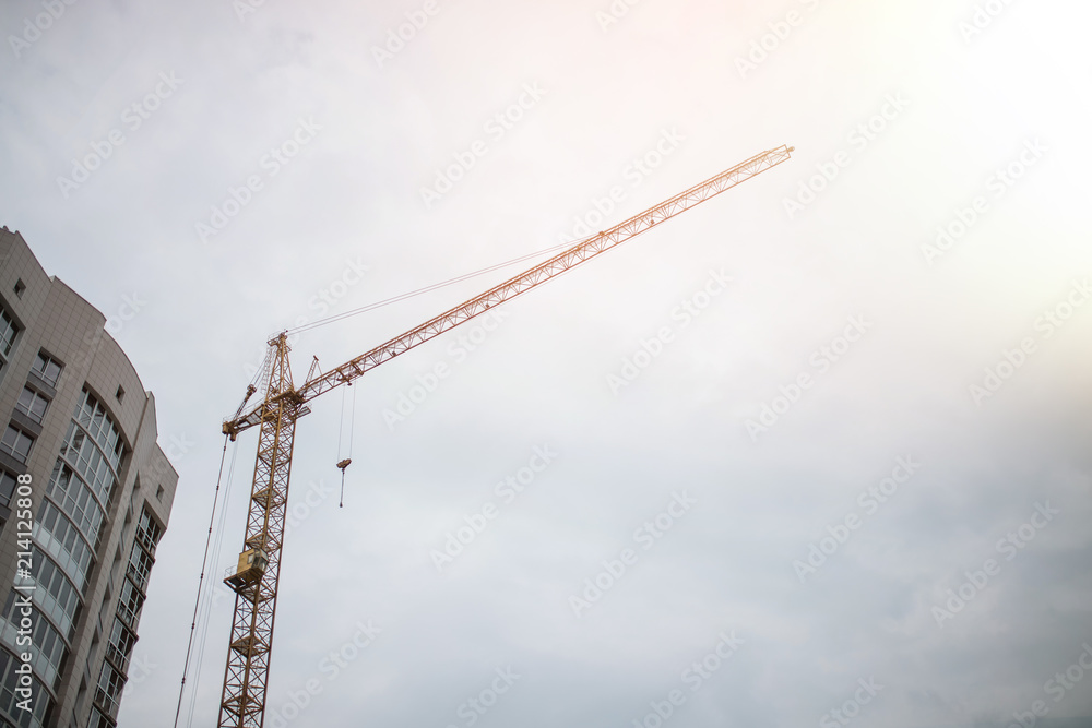Large crane and construction of building. Inside place for many tall buildings under construction and cranes under a blue sky