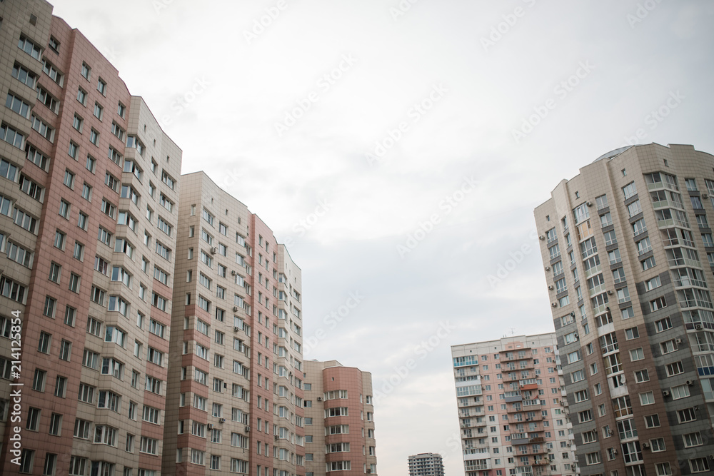 Newly constructed buildings above the transparent, cloudless blue sky. Multi-family houses, isolated on white background