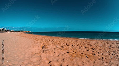 ALVOR, PORTUGAL, 12.06.2018: Sunny day at a beach, people walking by coastline, family summer vacation 