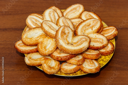 Wallpaper Mural Palmier biscuits - french cookies made of puff pastry (also called palm leaves, elephant ears or french hearts) in a plate on wooden table Torontodigital.ca