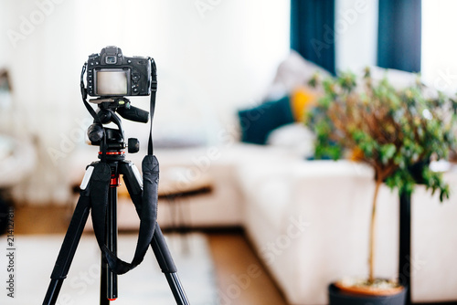 Camera on a tripod taking photographs of interior design, furniture and houses photo