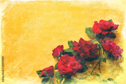 Red roses on a yellow background with grunge texture, the top view, the copy of space. Flower background 