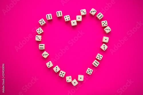 dice on a magenta background, in the shape of a heart photo