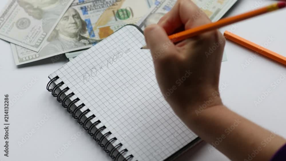 Calculating and taking notes in notebook, on working desk, money Calculating and taking notes in notebook, on working desk, money