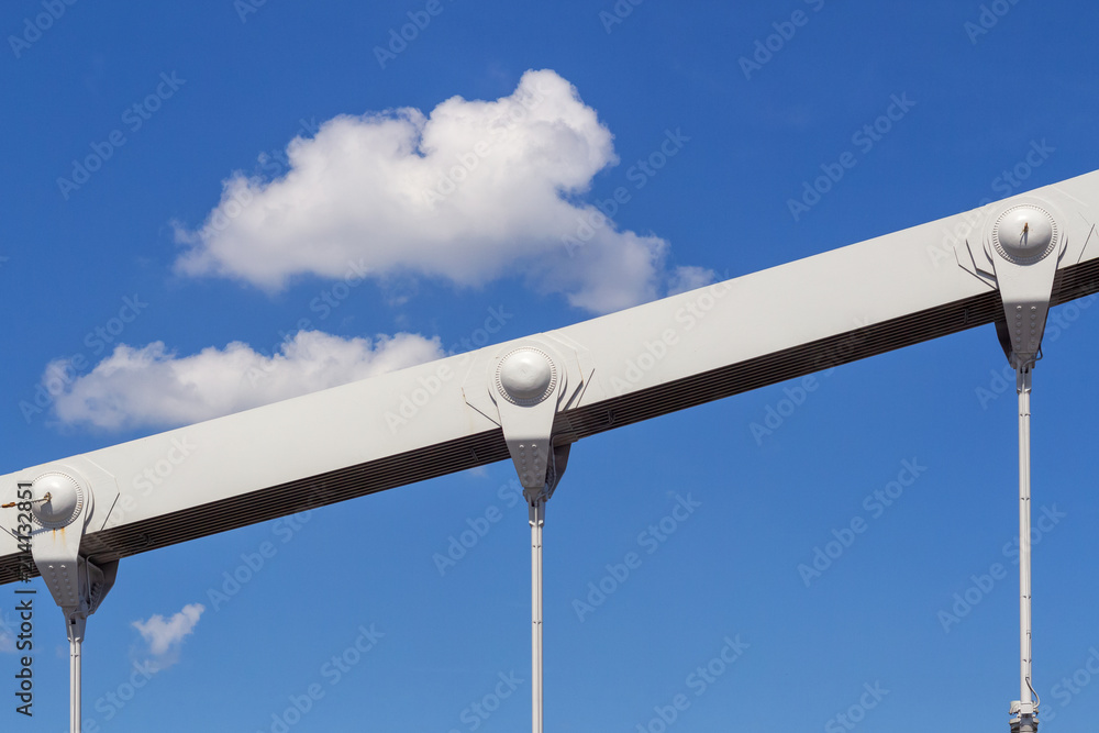 A fragment of the Crimean hanging bridge over the Moscow river against the blue sky with clouds A fragment of the Crimean hanging bridge over the Moscow river against the blue sky with clouds