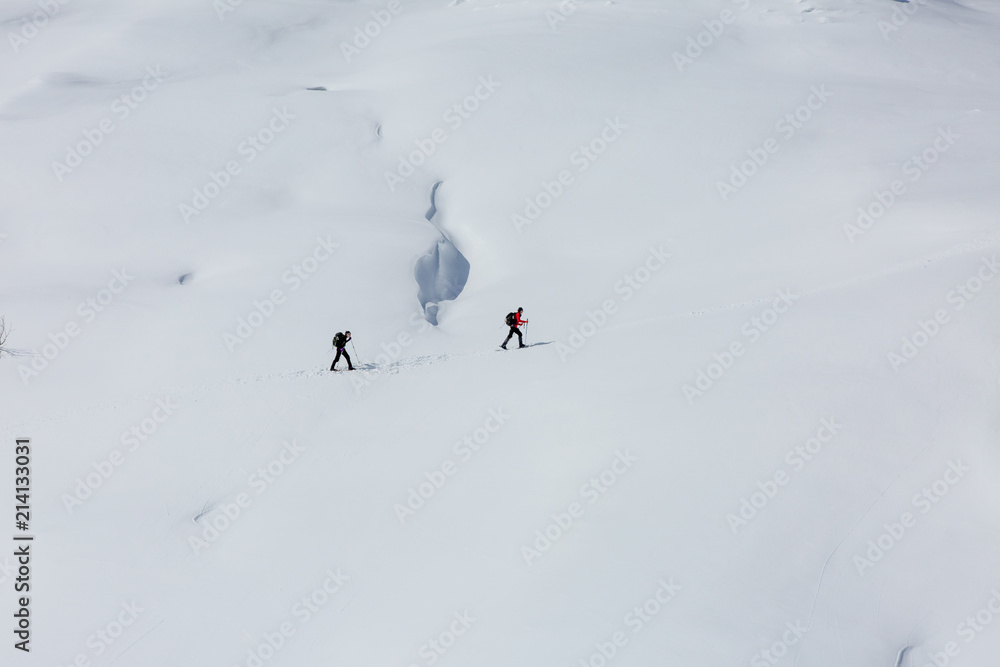 two tourists on the snowed sidehill of mountain. Alps, France, Bessans.