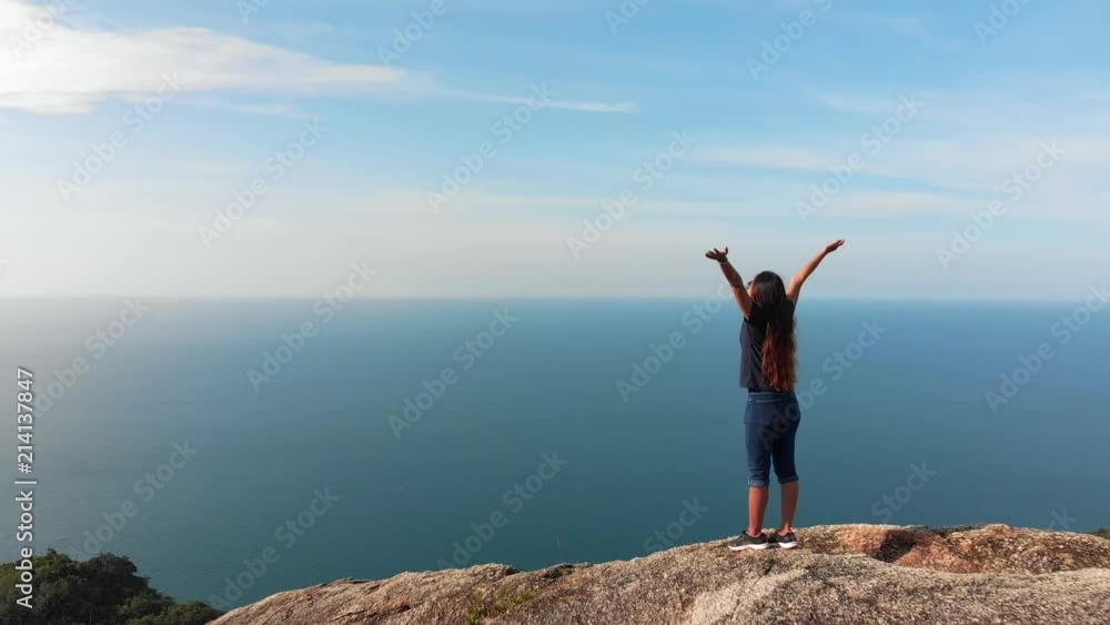 Woman with arms raised on top of mountain looking at Sunset view Hiker Girl lifting arm up celebrating life scenic nature landscape enjoying vacation travel adventure Woman with arms raised on top of mountain looking at Sunset view Hiker Girl lifting arm up celebrating life scenic nature landscape enjoying vacation travel adventure