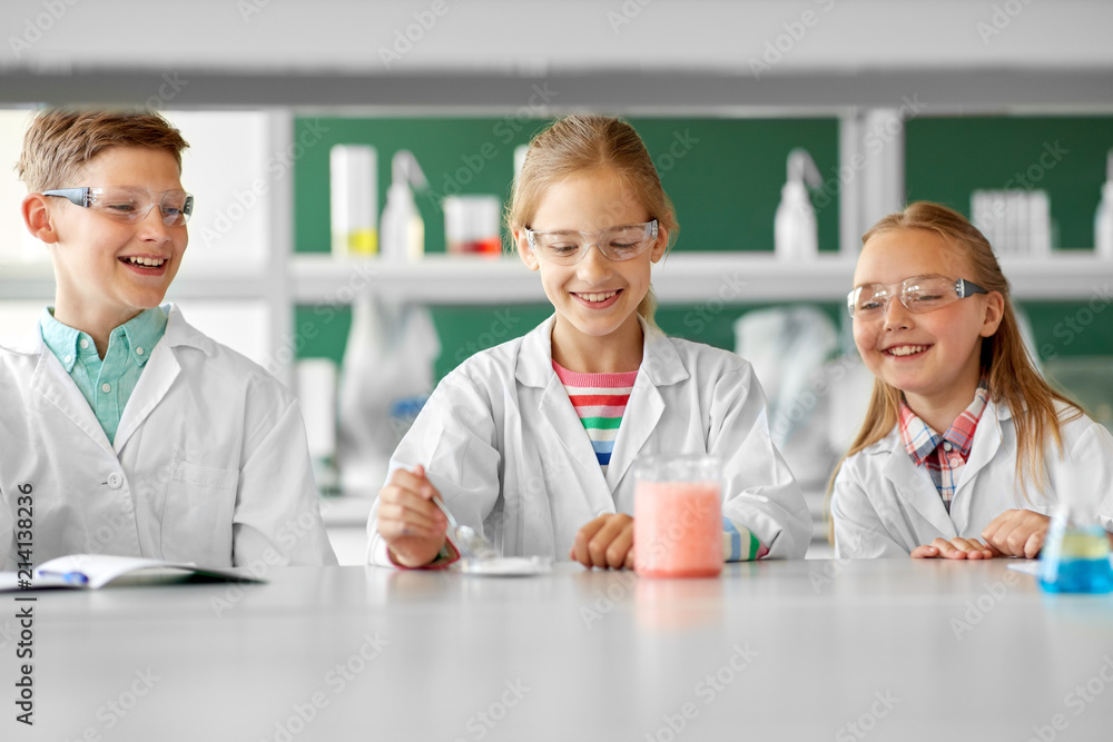 Fototapeta premium education, science, chemistry and children concept - kids or students with test tube making experiment at school laboratory