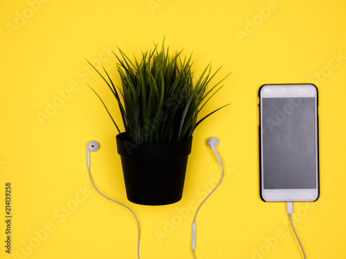Plant pot with headphones with smartphone photo