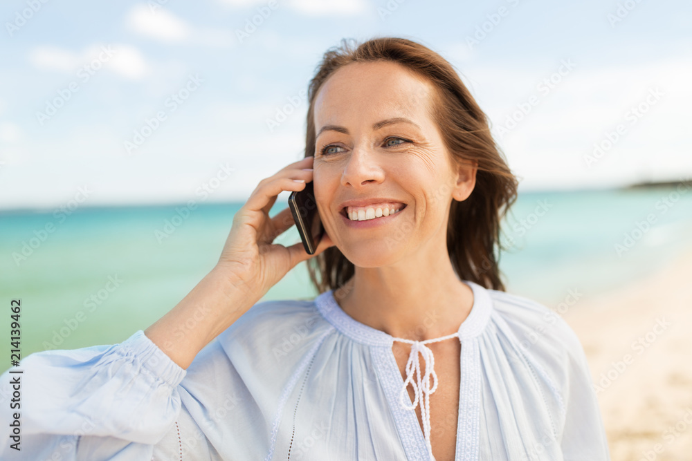 people and leisure concept - happy smiling woman calling on smartphone on summer beach people and leisure concept - happy smiling woman calling on smartphone on summer beach