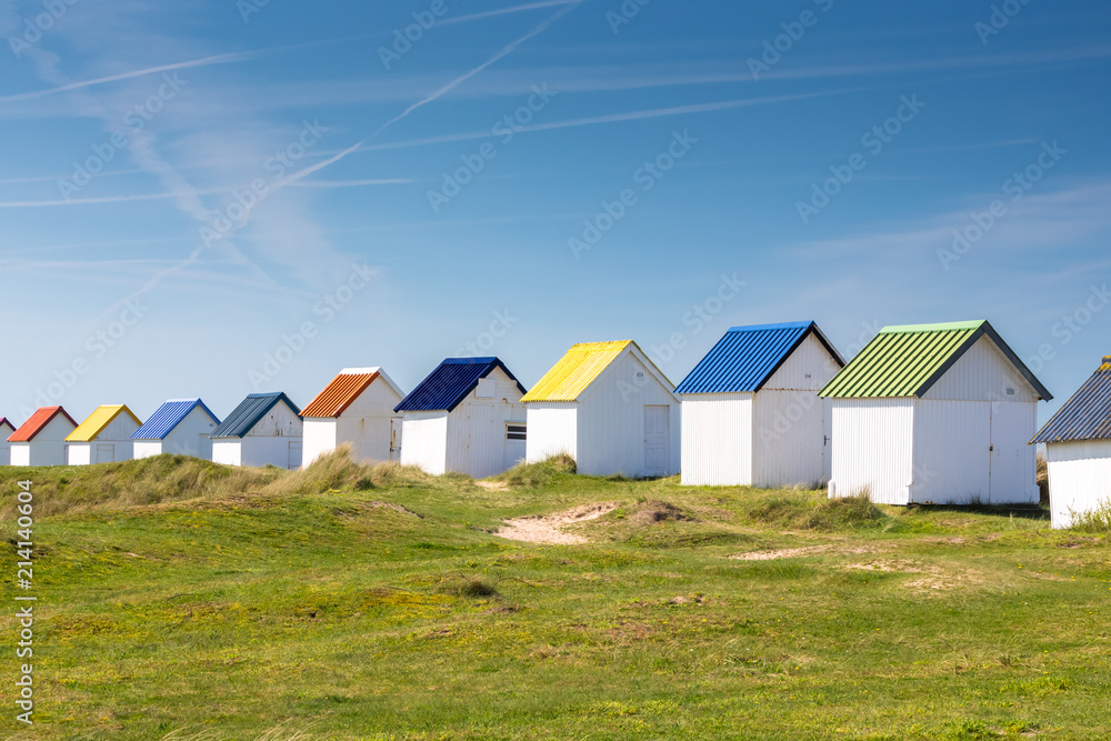 Colorful wooden beach cabins in the dunes, Gouville-sur-Mer, Normandy, France Colorful wooden beach cabins in the dunes, Gouville-sur-Mer, Normandy, France