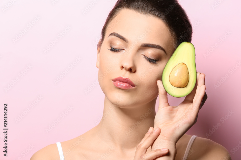 Beautiful young woman with avocado on color background Beautiful young woman with avocado on color background