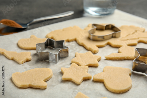 Cutters and raw Christmas cookies on table. Festive treats