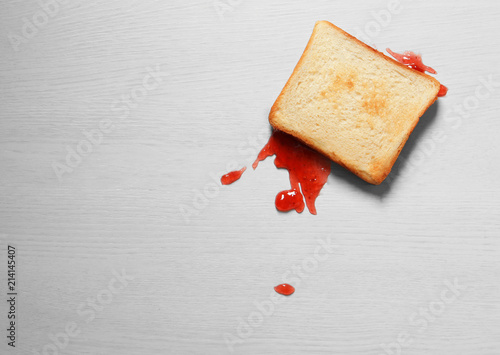 Overturned toast bread with jam on floor, top view