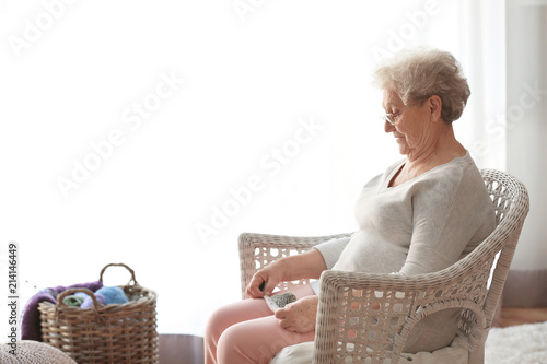 Elderly woman knitting in w...