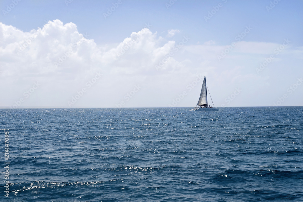 Lonely sailboat near the horizon in a calm sea 