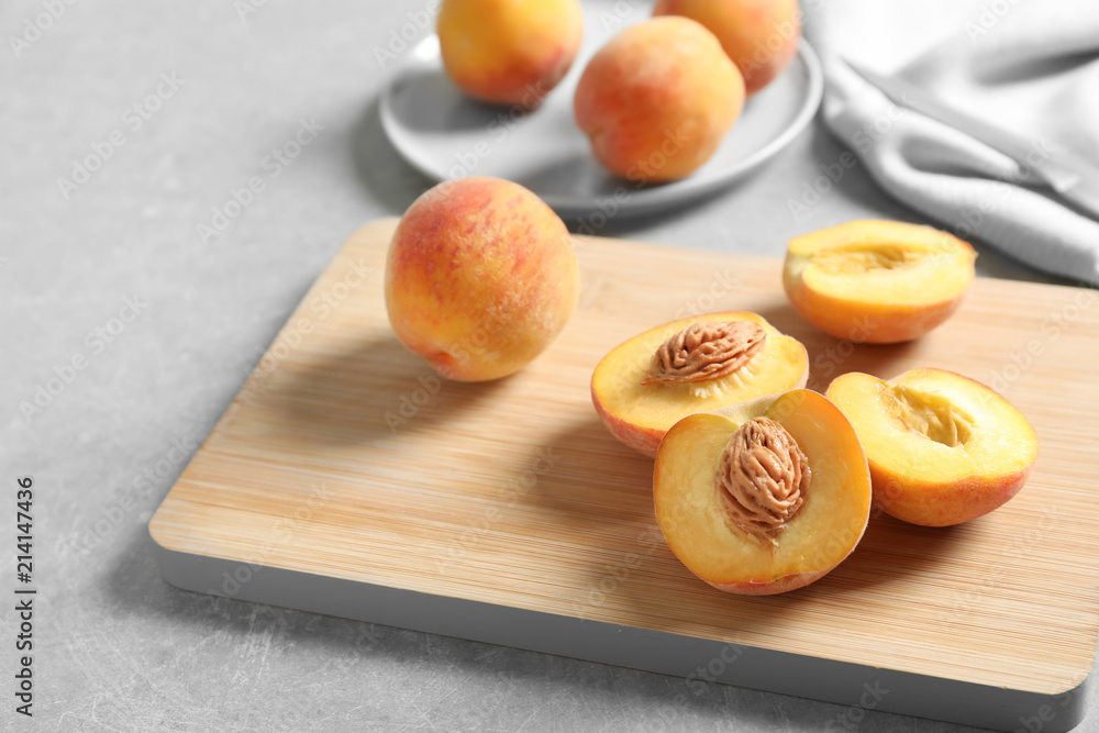 Wooden board with fresh sweet peaches on table, closeup