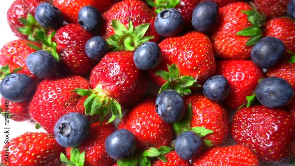 Red ripe garden strawberry and blueberry, rotation of berries on white table, beautiful background Red ripe garden strawberry and blueberry, rotation of berries on white table, beautiful background