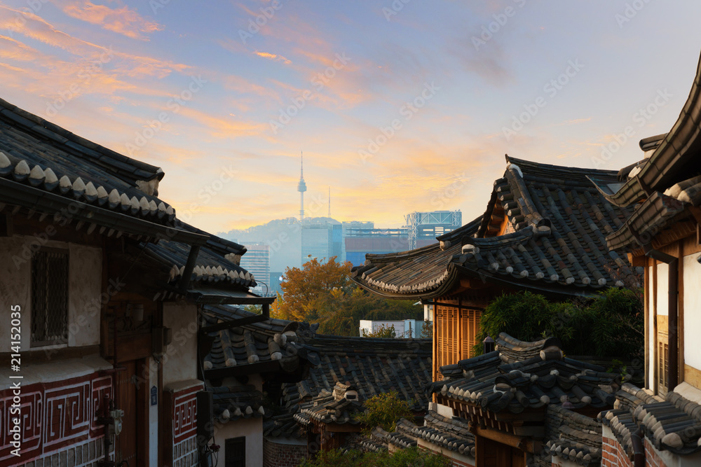 Traditional Korean style architecture at Bukchon Hanok Village with N Seoul Tower in background in Seoul, South Korea.