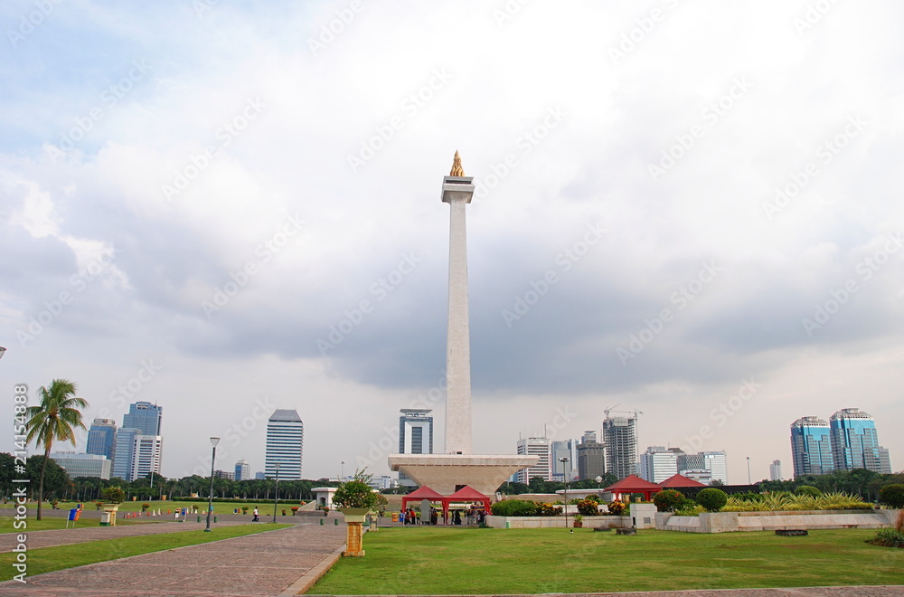 The National Monument in the centre of Merdeka Square with skyscrapers in the background, central Jakarta, Indonesia 