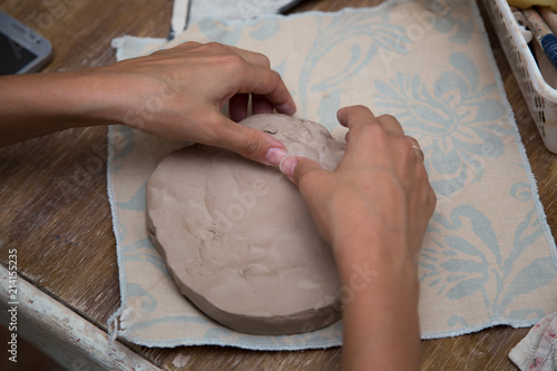 Woman working with clay with her hands close up at a pottery workshop