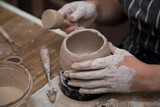 Woman working with clay with her hands close up at a pottery workshop