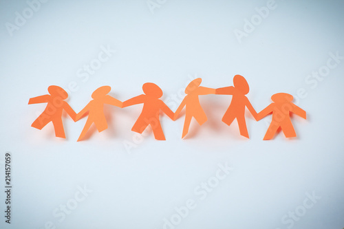 four paper men taking each other's hands