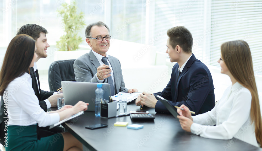 Manager and business group discussing financial documents Manager and business group discussing financial documents