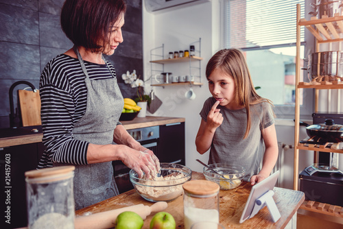 Mother and daughter tasting dough for apple pie