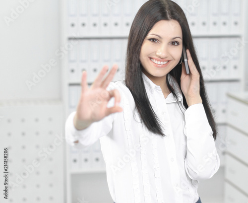 business woman talking on mobile phone and showing sign OK