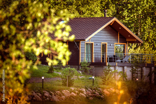 The house is surrounded by plants. House. Cottage surrounded by trees.