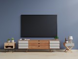 Smart TV on the dark wall in living room with cabinet,plants,lamp,minimal design,3d rendering