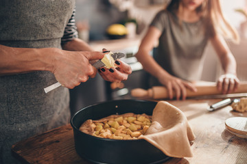 Woman cutting butter into apple pie